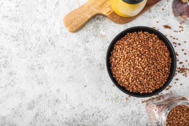 Açık arkaplanda karabuğday taneleri olan bir kase