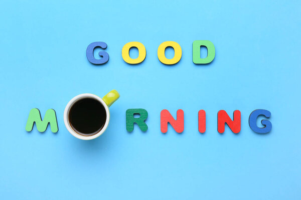 Cup of aromatic coffee and text GOOD MORNING on color background