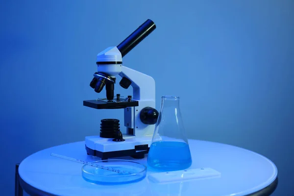 Mavi Duvarın Yanındaki Masada Üzerinde Örnekler Mikroskop Bulunan Farklı Laboratuvar — Stok fotoğraf