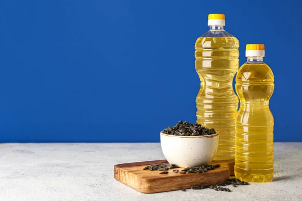 Bottles Oil Board Bowl Sunflower Seeds Table Blue Background — Stock Photo, Image