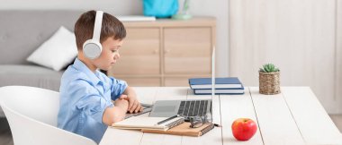 Küçük okul çocuğu evde online çalışıyor.