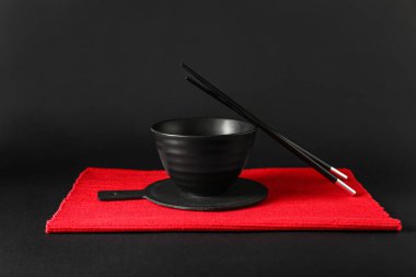 Koyu arkaplanda çubuklar olan Çin kâsesi.