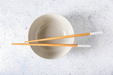 Hafif arka planda çubuklar olan Çin kâsesi.