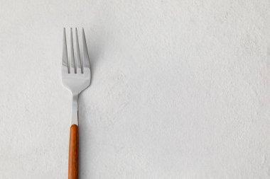 Işık zemininde paslanmaz çelik çatal, yakın plan.