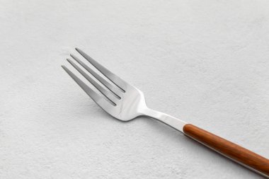 Işık zemininde paslanmaz çelik çatal, yakın plan.