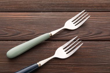 Koyu ahşap arka planda paslanmaz çelik çatallar.