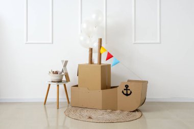 Balonlu oyuncak gemi ve ışık duvarının yanındaki masa.