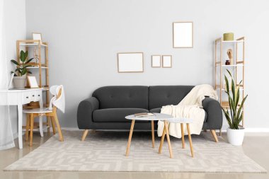 Gri kanepesi ve işyeri olan modern bir oda.