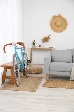 Şık oturma odasında rahat bir kanepe ve bisiklet.