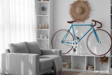 Bisiklet, raf ünitesi ve kanepesi olan modern oturma odasının içinde.