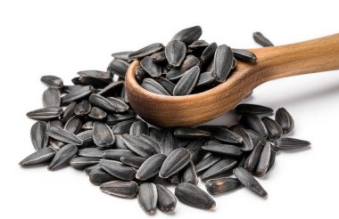 Tahta kaşık ve soyulmamış ayçiçeği tohumları beyaz arka planda, yakın plan