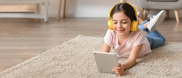 Κοριτσάκι Ακουστικά Και Tablet Υπολογιστή Ακούγοντας Μουσική Στο Σπίτι — Φωτογραφία Αρχείου