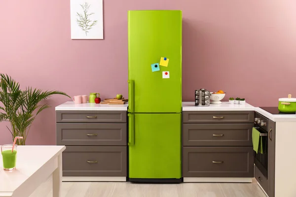 Interior of modern kitchen with green refrigerator