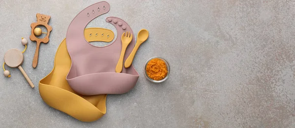 Siliconen Babyslabbetjes Met Plastic Bestek Eten Speelgoed Grunge Achtergrond Met — Stockfoto