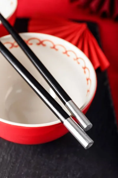 Chinese bowl with chopsticks on table, closeup