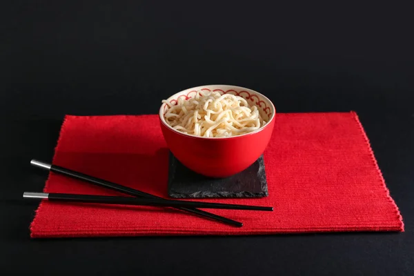 在深色背景下用好吃的面条和筷子做的碗 — 图库照片