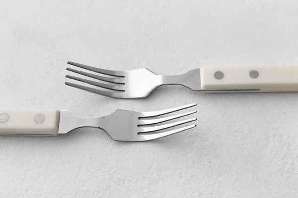 Stylish Stainless Steel Forks Light Background Close Seup — стоковое фото