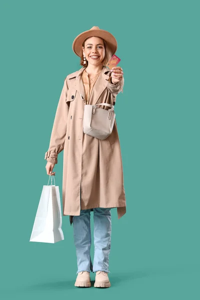 Junge Frau Mit Kreditkarte Und Einkaufstasche Auf Grünem Hintergrund — Stockfoto