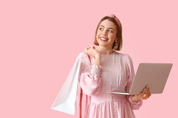 Junge Frau Mit Laptop Und Einkaufstasche Auf Rosa Hintergrund — Stockfoto