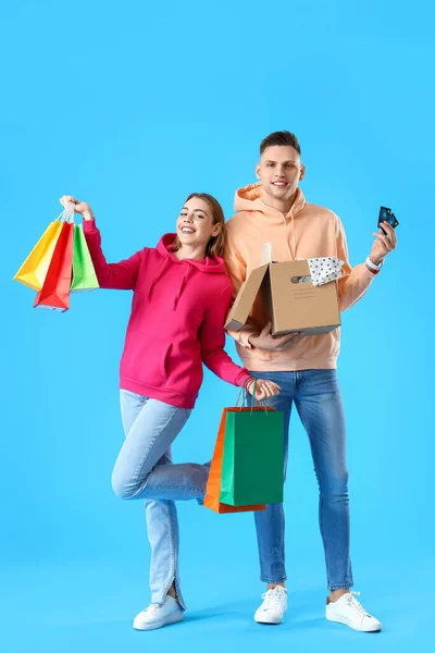 Fiatal Pár Hitelkártyával Bevásárlótáskával Kék Hátterű Parcellával — Stock Fotó