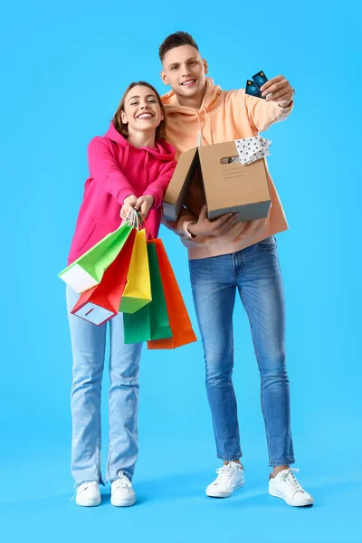 Unga Par Med Kreditkort Kassar Och Paket Blå Bakgrund — Stockfoto