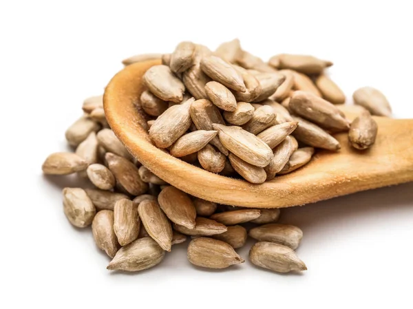 Tahta kaşık ve kabuklu ayçiçeği tohumları beyaz arka planda, yakın plan