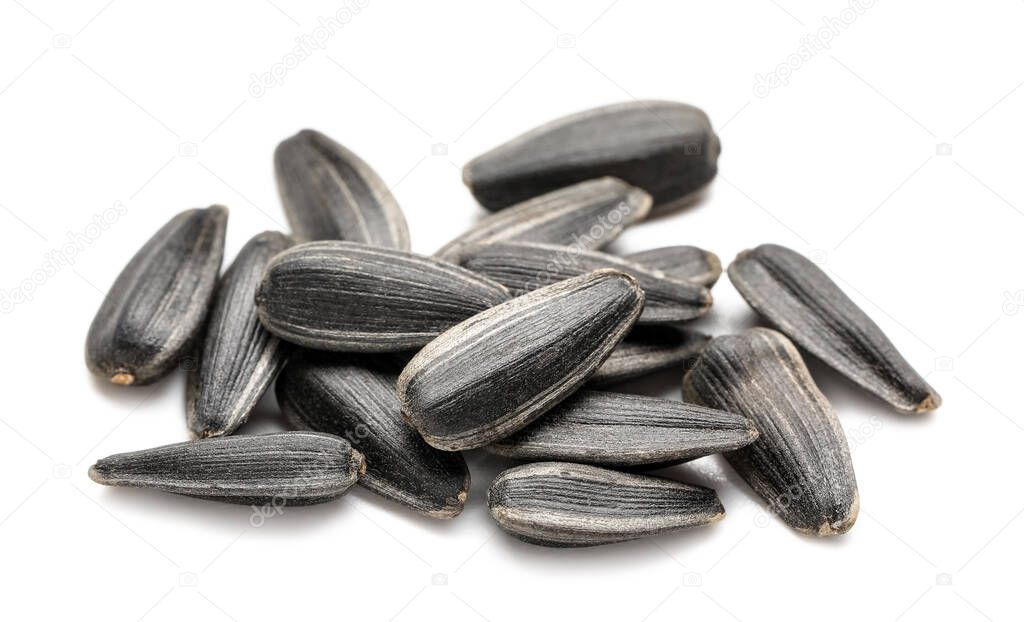 Heap of unpeeled sunflower seeds on white background