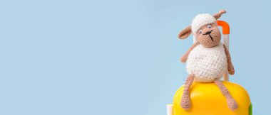 Mavi arka planda çocuk oyuncağı dolu bavul ve mesaj için yer var