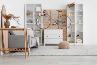 Bisiklet, sörf tahtası ve çekmeceli modern oturma odası.