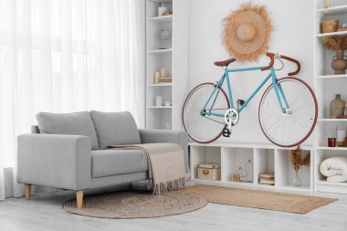 Bisiklet, raf ünitesi ve kanepesi olan modern oturma odasının içinde.