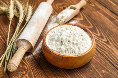 Buğday kulakları, merdane, kepçe ve kase, ahşap arka planda un, yakın plan