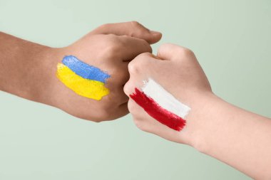 Ukrayna ve Polonya 'nın bayraklarını taşıyan gönüllüler yeşil zemine yumruk sallıyor