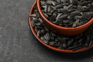 Koyu arkaplanda siyah ayçiçeği tohumları, yakın plan.