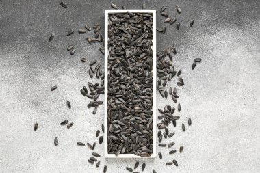 Siyah ve beyaz arkaplanda ayçiçeği tohumları olan tahta