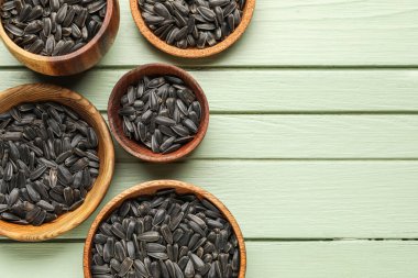 Yeşil ahşap arka planda siyah ayçiçeği tohumları