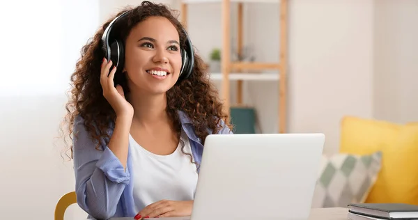 Afroamerikanerin Mit Kopfhörer Hört Musik Während Sie Hause Laptop Arbeitet — Stockfoto