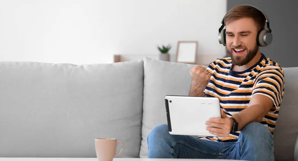 Happy Young Man Tablet Computer Headphones Sitting Sofa — Stock Photo, Image