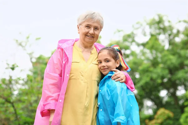 Little Girl Her Grandma Raincoats Hugging Outdoors — Stock Photo, Image