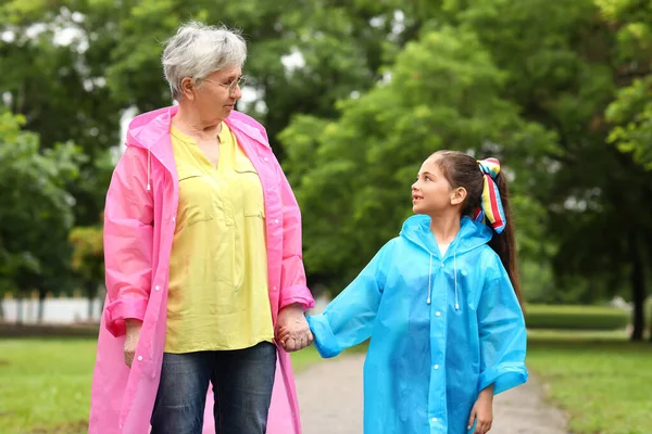 Little Girl Her Grandma Raincoats Holding Hands Outdoors — Stock Photo, Image