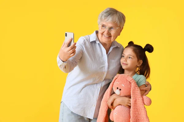 Petite Fille Avec Jouet Grand Mère Prenant Selfie Sur Fond — Photo