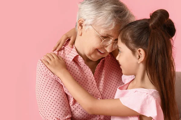Senior Vrouw Met Haar Kleine Kleindochter Knuffelen Roze Achtergrond — Stockfoto