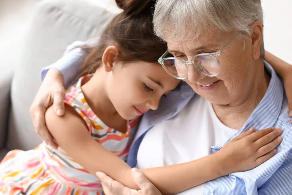 Küçük kız büyükannesine sarılıyor, yakın çekim.