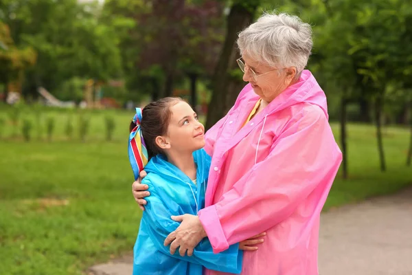 Κοριτσάκι Και Γιαγιά Της Αδιάβροχα Αγκαλιάζονται Έξω — Φωτογραφία Αρχείου