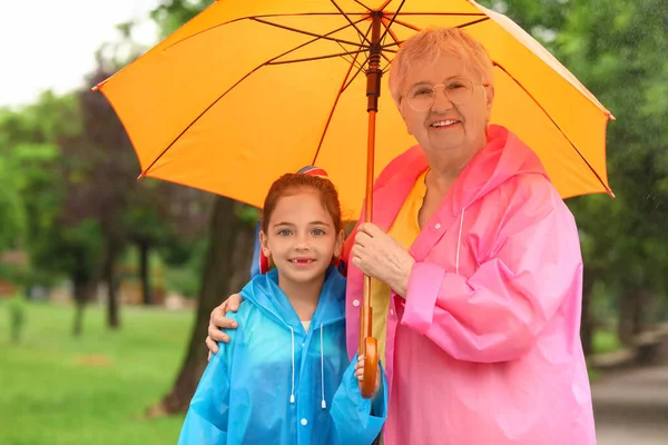 Κοριτσάκι Και Γιαγιά Της Αδιάβροχα Και Ομπρέλα Έξω — Φωτογραφία Αρχείου