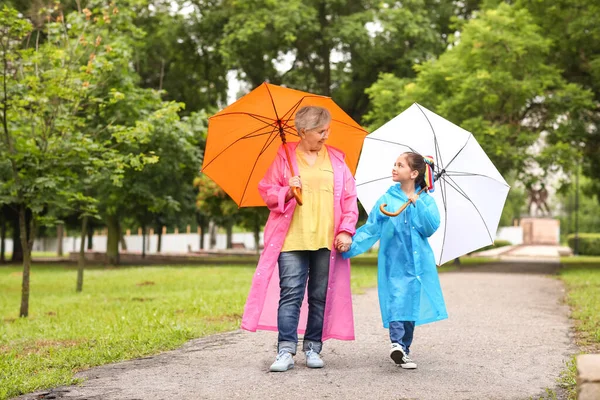 Little Girl Her Grandma Raincoats Umbrellas Walking Outdoors — Stock Photo, Image