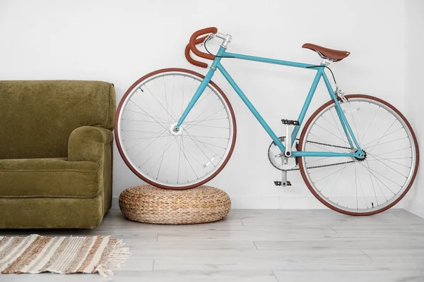 Modern bicycle and sofa near light wall in living room