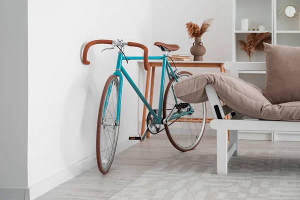 Modern bicycle near light wall in living room
