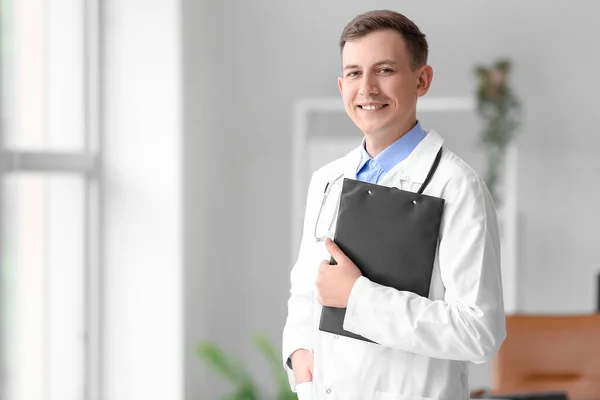 Male medical assistant with clipboard at hospital