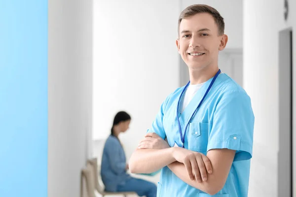 Male medical assistant smiling in clinic
