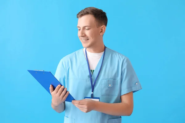 Male Medical Assistant Clipboard Blue Background — Stock Photo, Image